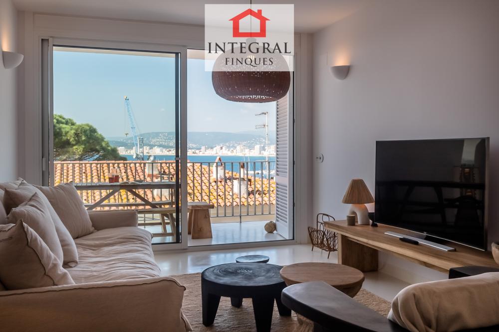 Sala d'estar de disseny, decorada amb un estil boho, amb sortida a terrassa  i vistes al mar