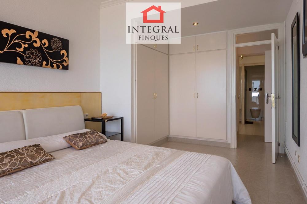 Habitació principal amb llit de matrimoni i armaris empotrats.