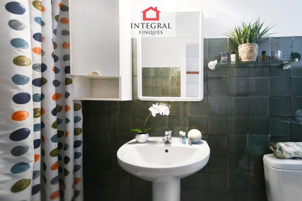 Lavabo amb una petita pica ambientat amb el color verd i blanc.