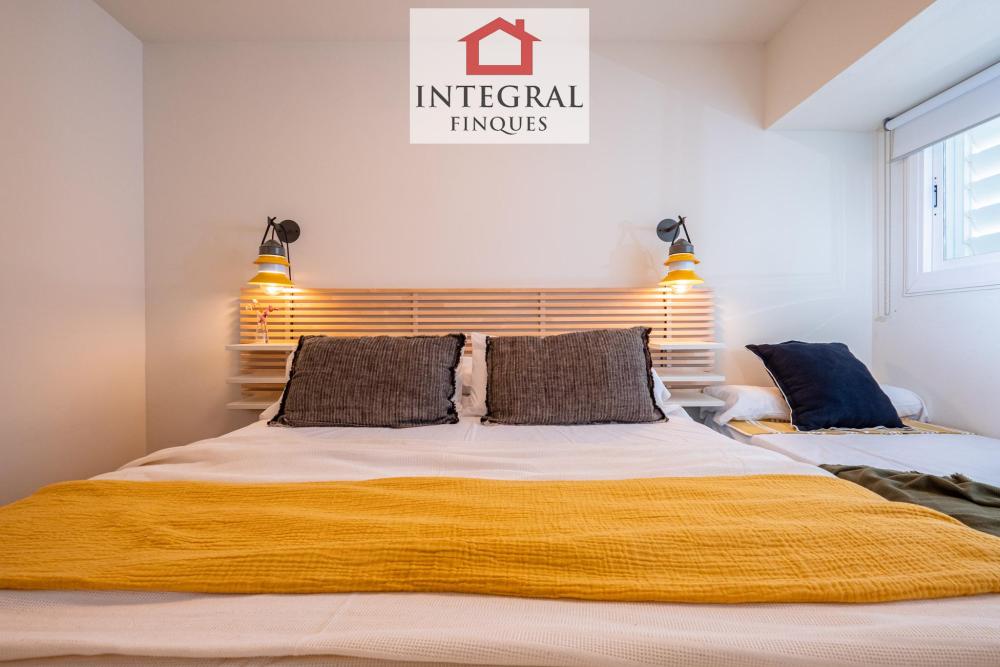 Habitació de matrimoni amb un llit individual al costat.