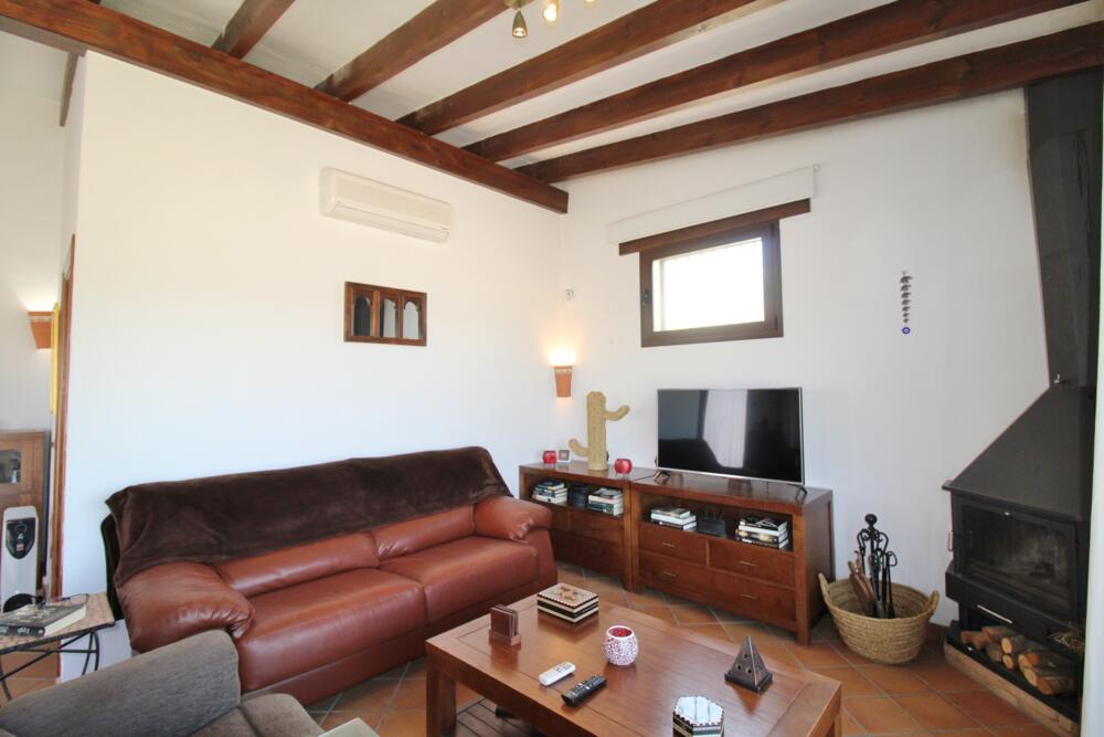 Preciosa sala d'estar amb sofa,  televisió i llibres