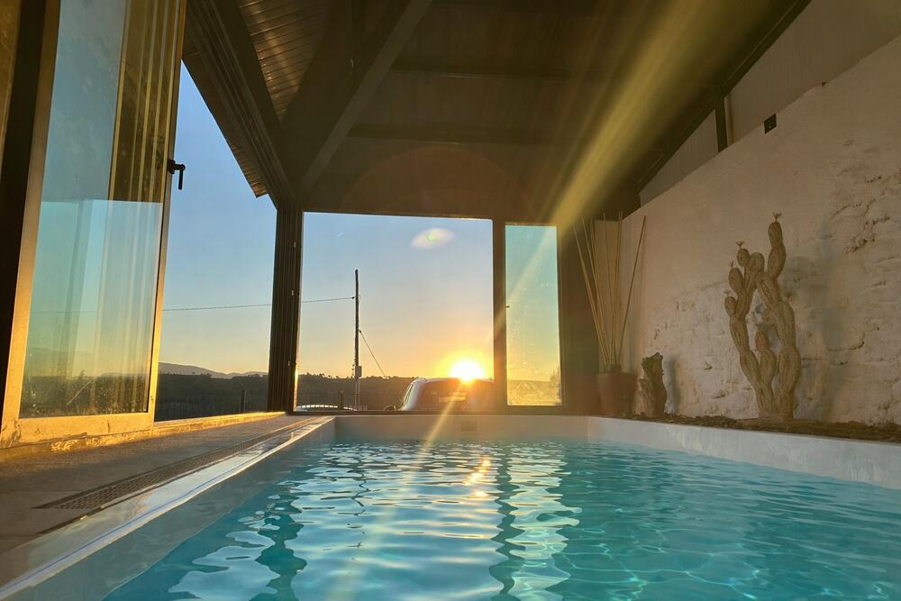 Gaudeix de la calma dins la piscina amb mirant com cau el sol.
