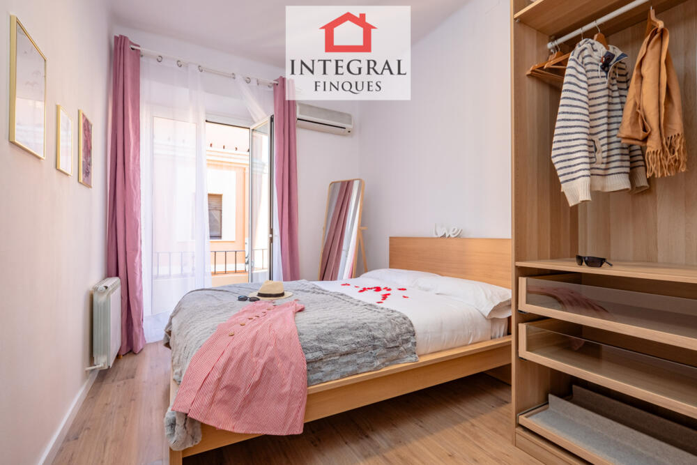 Habitació amb balcó i un petit armari-vestidor.