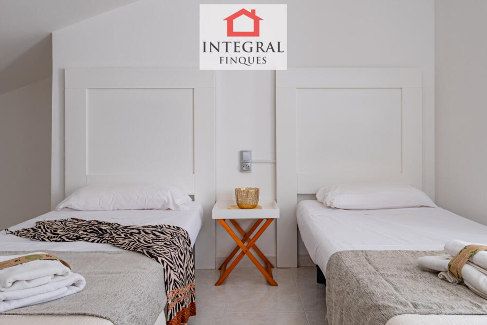 Habitació amb dos llits individuals amb endoll al costat.