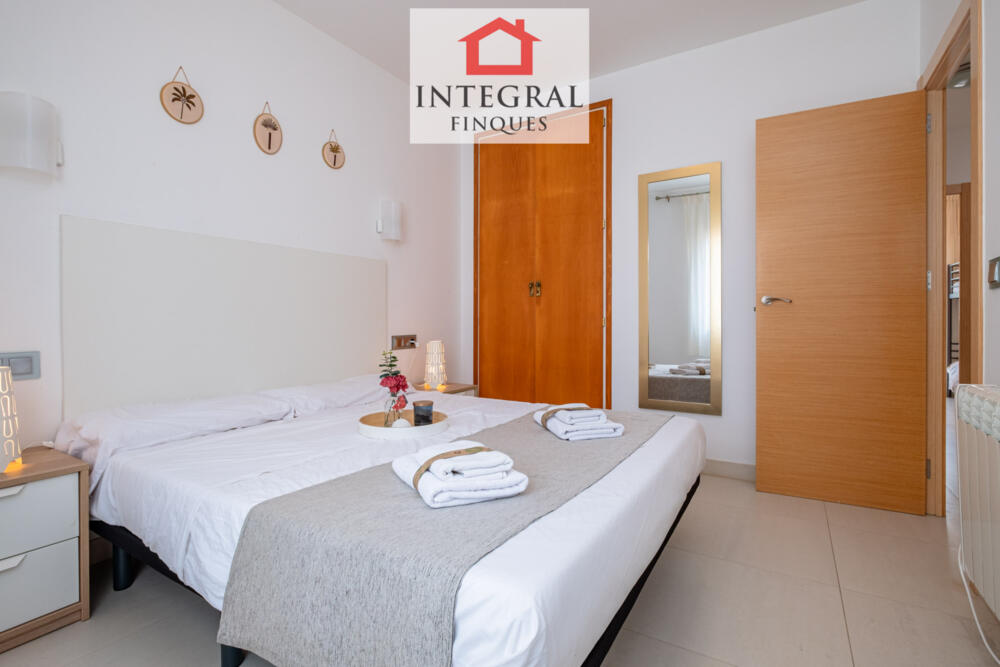 Habitació de matrimoni amb un petit armari i elegant mirall.