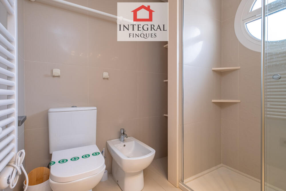 Lavabo amb bidet i una gran dutxa.
