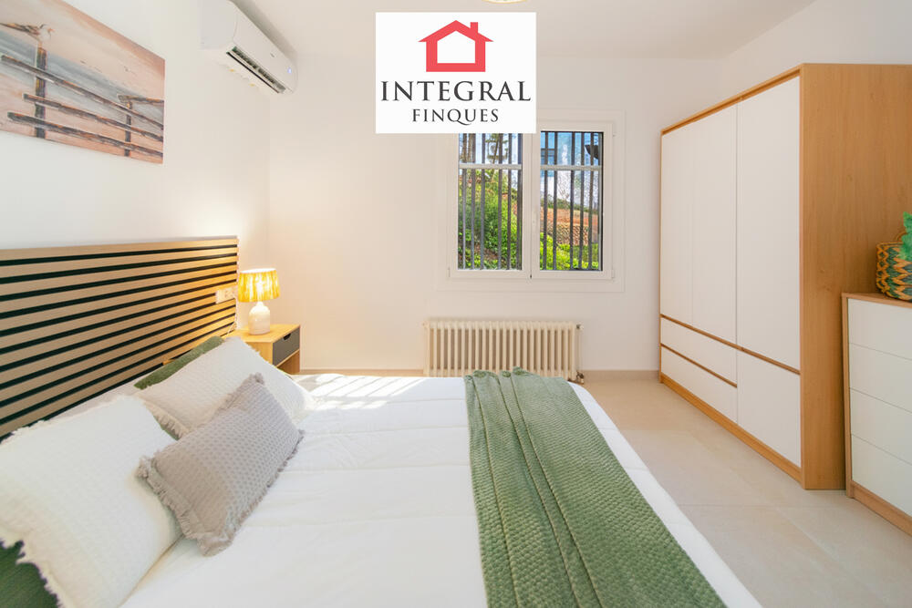 Habitació de matrimoni amb gran finestral que aporta molta lluminositat.