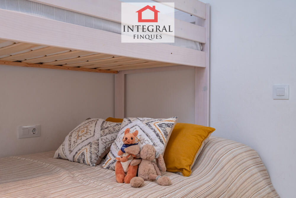 Habitació ampla amb espai d'emmagatzematge amb armaris de paret.