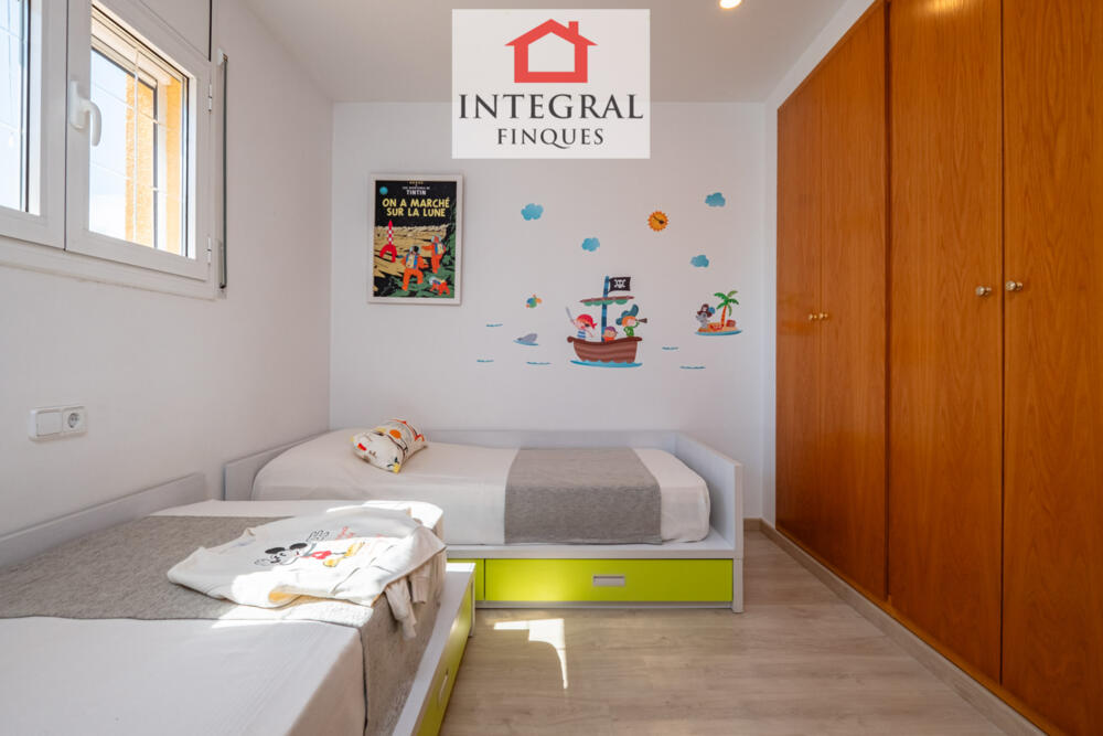 Habitació infantil amb un gran armari per guardar el necessari.