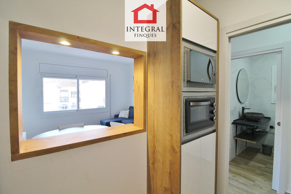 Finestra que connecta la cuina amb la sala d'estar-menjador. Finestra que connecta la cuina amb la sala d'estar-menjador.