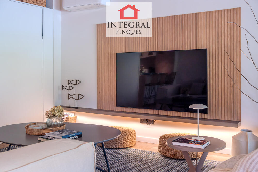 Detalls de la zona d'estar, amb una àmplia televisió i una decoració elegant. Detalls de la zona d'estar, amb una àmplia televisió i una decoració elegant.