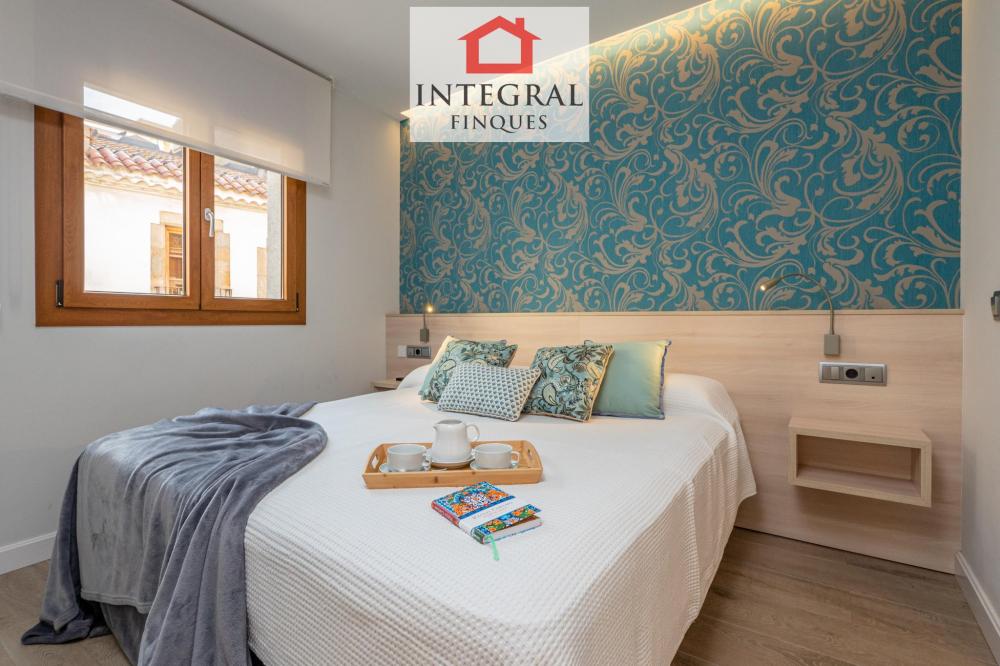 Habitació principal amb llit de matrimoni i armaris empotrats.