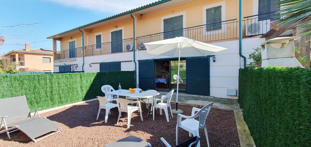 Hinterer Garten mit Tisch, Terrassenstühlen und Sonnenschirm Hinterer Garten mit Tisch, Terrassenstühlen und Sonnenschirm
