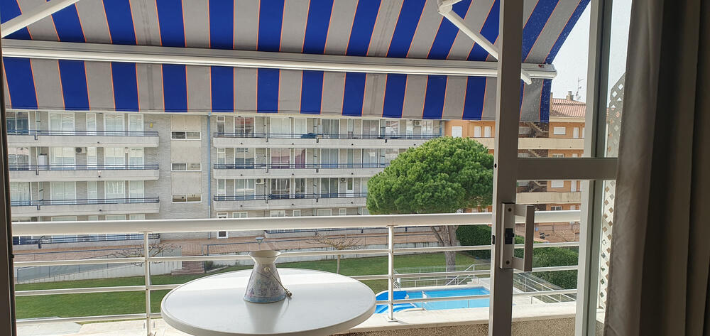 Terrasse mit Markise mit Blick auf den Gemeinschaftspool