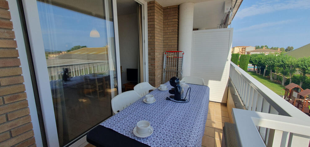Terrasse mit Tisch und Terrassenstühlen mit Blick auf den Gemeinschaftsbereich.