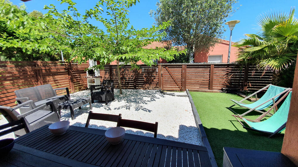 Garten mit Sonnenliegen, Gartenmöbeln und Grill