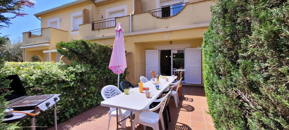 Terrasse mit großem Tisch und Stühlen neben dem Pool