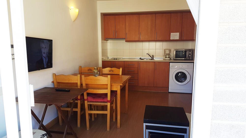 Wohnzimmer mit Sofa, offene Küche und Esszimmer