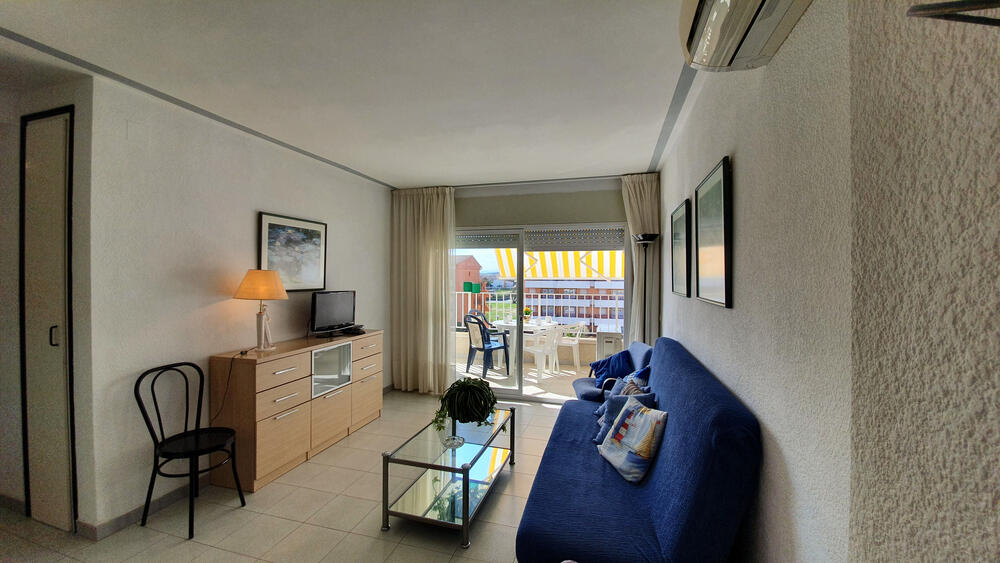 Wohnzimmer mit Sofa TV und neben der Terrasse