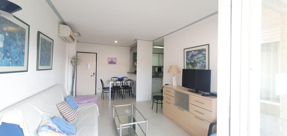 Wohnzimmer mit Sofa TV und neben der Terrasse