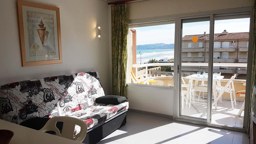 Wohnzimmer mit Sofa und angrenzender Terrasse mit Meerblick