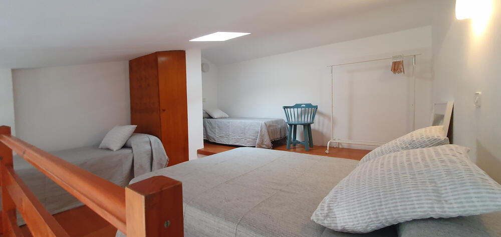 Offener Dachboden mit einem Doppelbett und zwei Einzelbetten