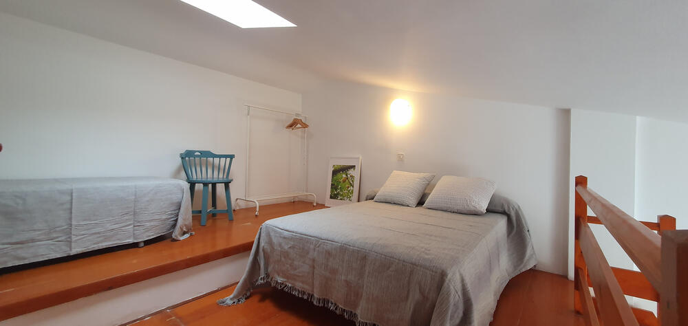 Offener Dachboden mit Betten und einem Fenster an der Decke
